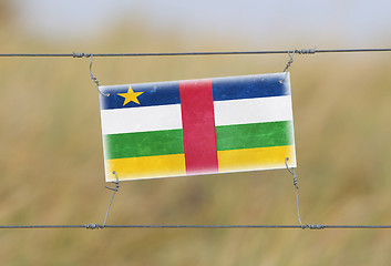 Image showing Border fence - Old plastic sign with a flag