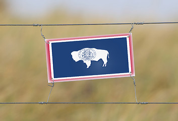 Image showing Border fence - Old plastic sign with a flag