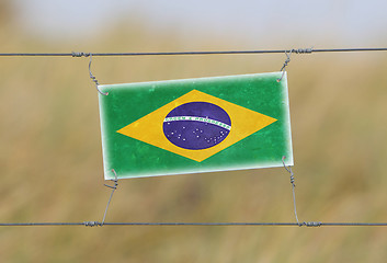 Image showing Border fence - Old plastic sign with a flag