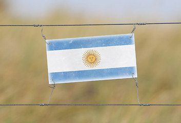 Image showing Border fence - Old plastic sign with a flag