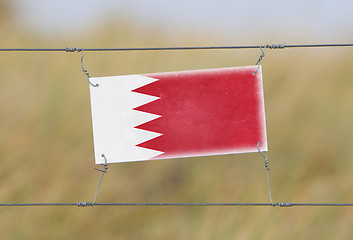 Image showing Border fence - Old plastic sign with a flag