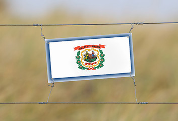 Image showing Border fence - Old plastic sign with a flag