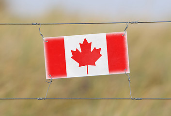 Image showing Border fence - Old plastic sign with a flag