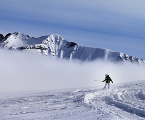 Image showing Snowboarder downhill on off-piste slope with newly fallen snow