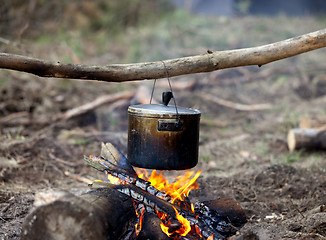 Image showing Cooking in sooty cauldron on campfire 