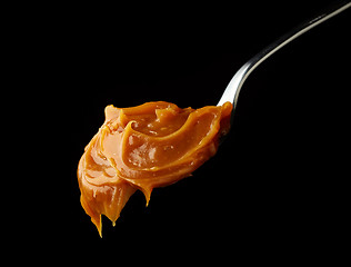 Image showing Spoon of melted caramel cream