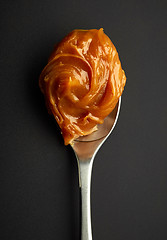 Image showing Spoon of melted caramel cream