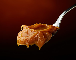 Image showing Spoon of melted caramel cream