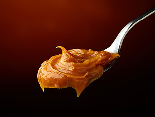 Image showing Spoon of melted caramel cream