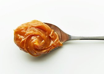 Image showing Spoon of melted caramel cream