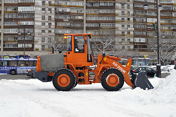 Image showing The bulldozer occupied with snow cleaning costs on the street in