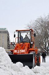 Image showing The bulldozer occupied with snow cleaning costs on the street in