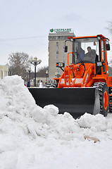 Image showing The bulldozer occupied with snow cleaning costs on the street in