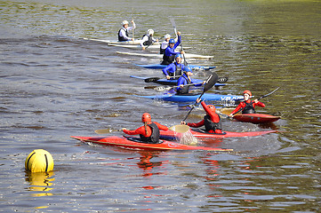 Image showing teenagers on kayaks float down the river.