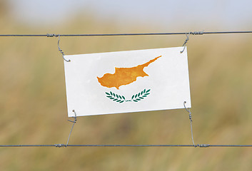 Image showing Border fence - Old plastic sign with a flag