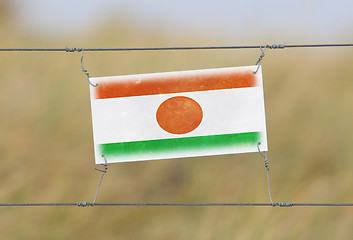 Image showing Border fence - Old plastic sign with a flag