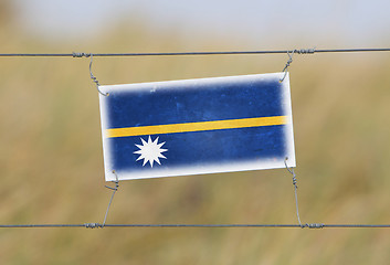 Image showing Border fence - Old plastic sign with a flag