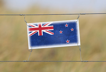 Image showing Border fence - Old plastic sign with a flag