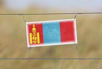 Image showing Border fence - Old plastic sign with a flag