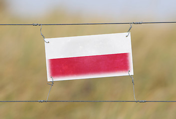 Image showing Border fence - Old plastic sign with a flag