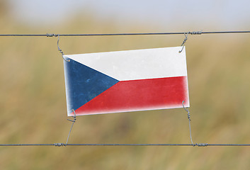 Image showing Border fence - Old plastic sign with a flag