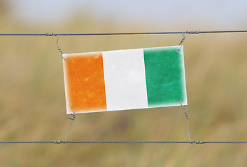 Image showing Border fence - Old plastic sign with a flag