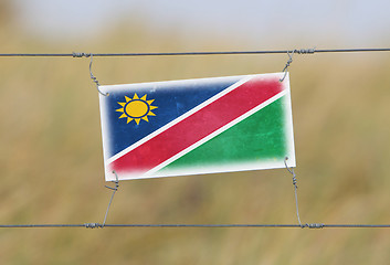 Image showing Border fence - Old plastic sign with a flag