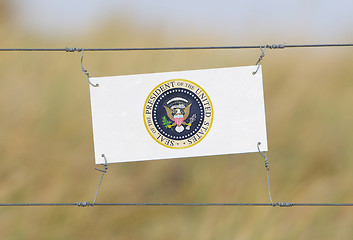 Image showing Border fence - Old plastic sign with a flag