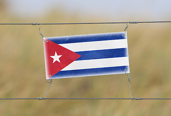 Image showing Border fence - Old plastic sign with a flag