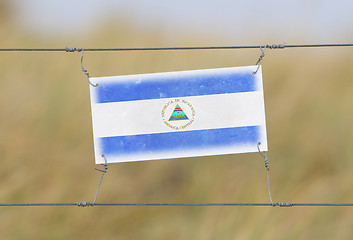 Image showing Border fence - Old plastic sign with a flag