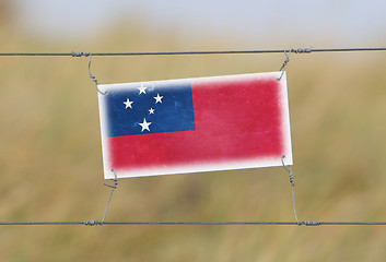 Image showing Border fence - Old plastic sign with a flag