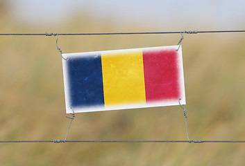 Image showing Border fence - Old plastic sign with a flag