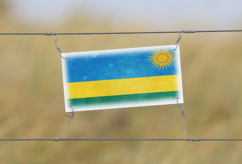 Image showing Border fence - Old plastic sign with a flag