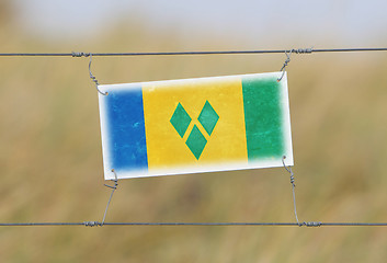 Image showing Border fence - Old plastic sign with a flag