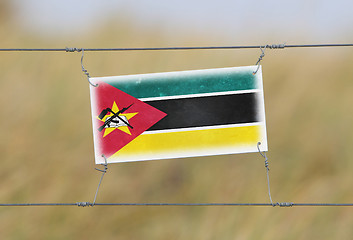 Image showing Border fence - Old plastic sign with a flag