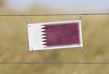 Image showing Border fence - Old plastic sign with a flag