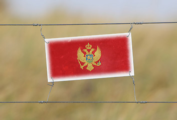 Image showing Border fence - Old plastic sign with a flag