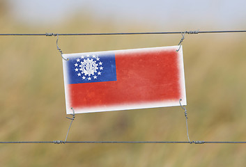 Image showing Border fence - Old plastic sign with a flag