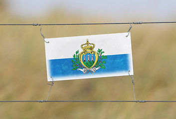 Image showing Border fence - Old plastic sign with a flag