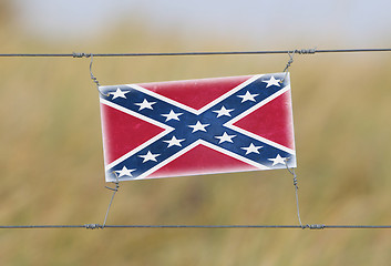 Image showing Border fence - Old plastic sign with a flag