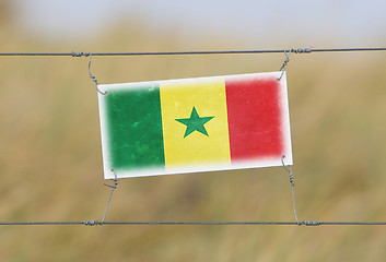 Image showing Border fence - Old plastic sign with a flag