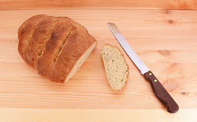 Image showing Bread knife with a freshly baked loaf