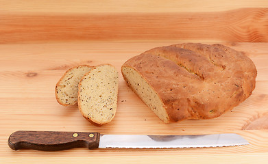 Image showing Bread knife with slices of bread cut from a loaf