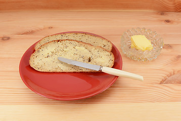 Image showing Buttered slices of bread on a red plate 