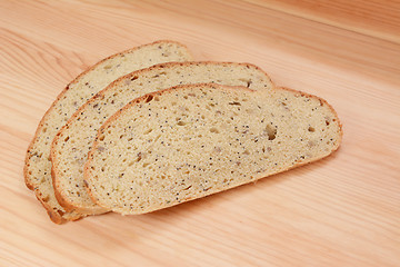 Image showing Three slices of bread on a wooden table