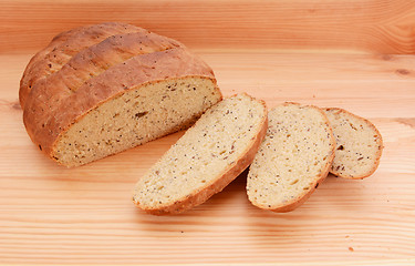 Image showing Three slices of fresh bread next to the loaf