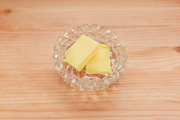 Image showing Two pats of butter in a glass dish