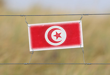 Image showing Border fence - Old plastic sign with a flag