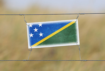 Image showing Border fence - Old plastic sign with a flag