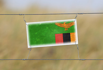 Image showing Border fence - Old plastic sign with a flag